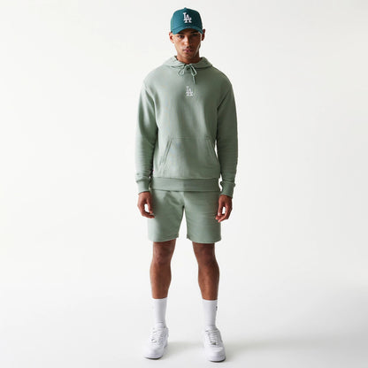 New Era LA Dodgers MLB Midi Green Oversized Pullover Hoodie, front view on a model with matching shorts and cap, displaying an embroidered LA logo on the centre chest and a large kangaroo pocket at the front.