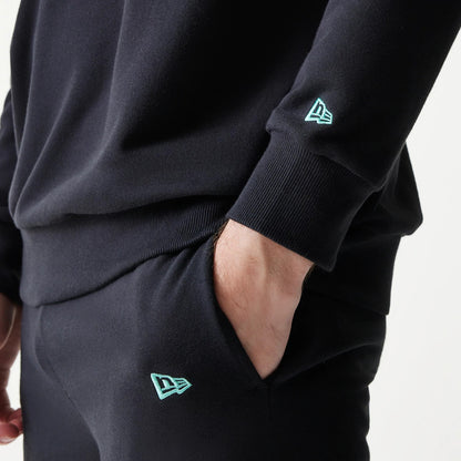 New Era Chicago Bulls NBA Black Oversized Crew Neck Sweater, close-up view showing the ribbed cuffs and the light blue embroidered New Era flag logo on the left sleeve, with a casual fit.