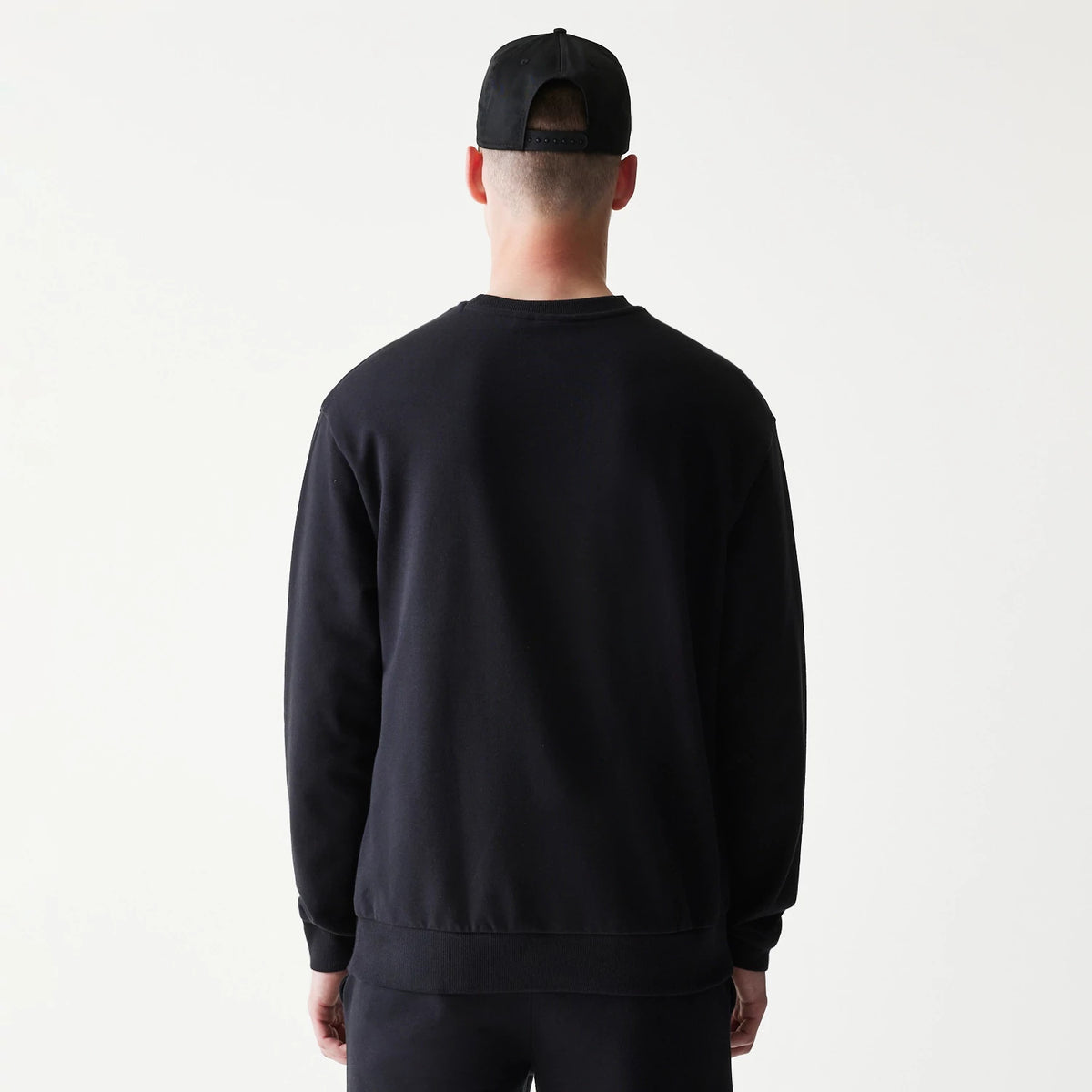The model is wearing this NBA League Essential Chicago Bulls Oversized Crew Neck Sweater in black. 2