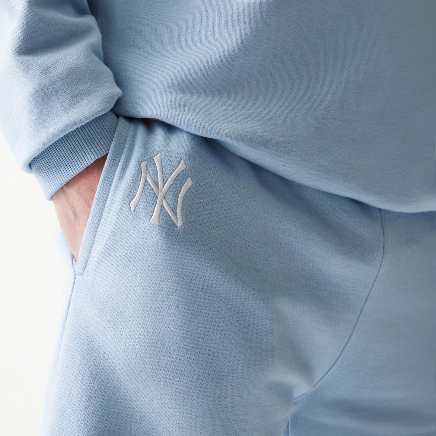 The model is wearing this MLB League Essential Midi New York Yankees Shorts in pastel blue. 4
