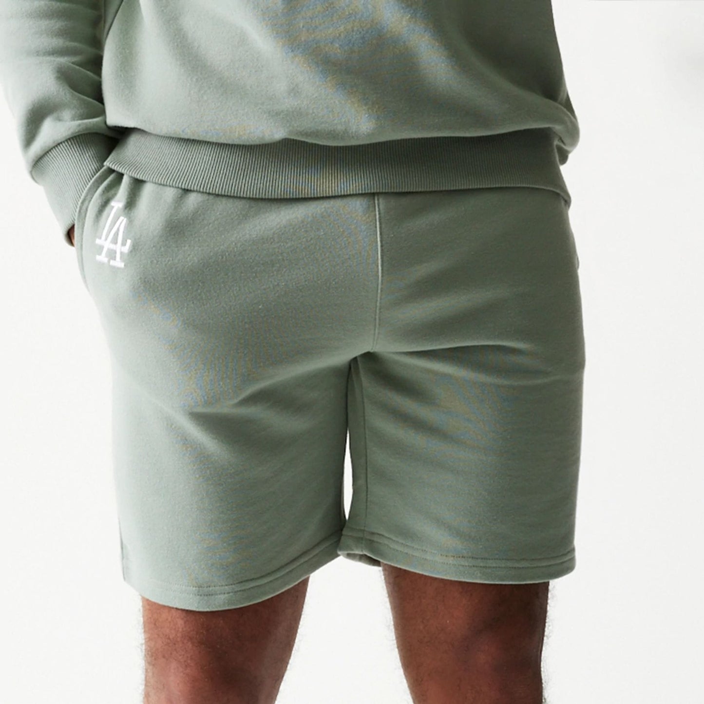 The model is wearing this MLB League Essential Midi LA Dodgers Shorts in pastel green. 5