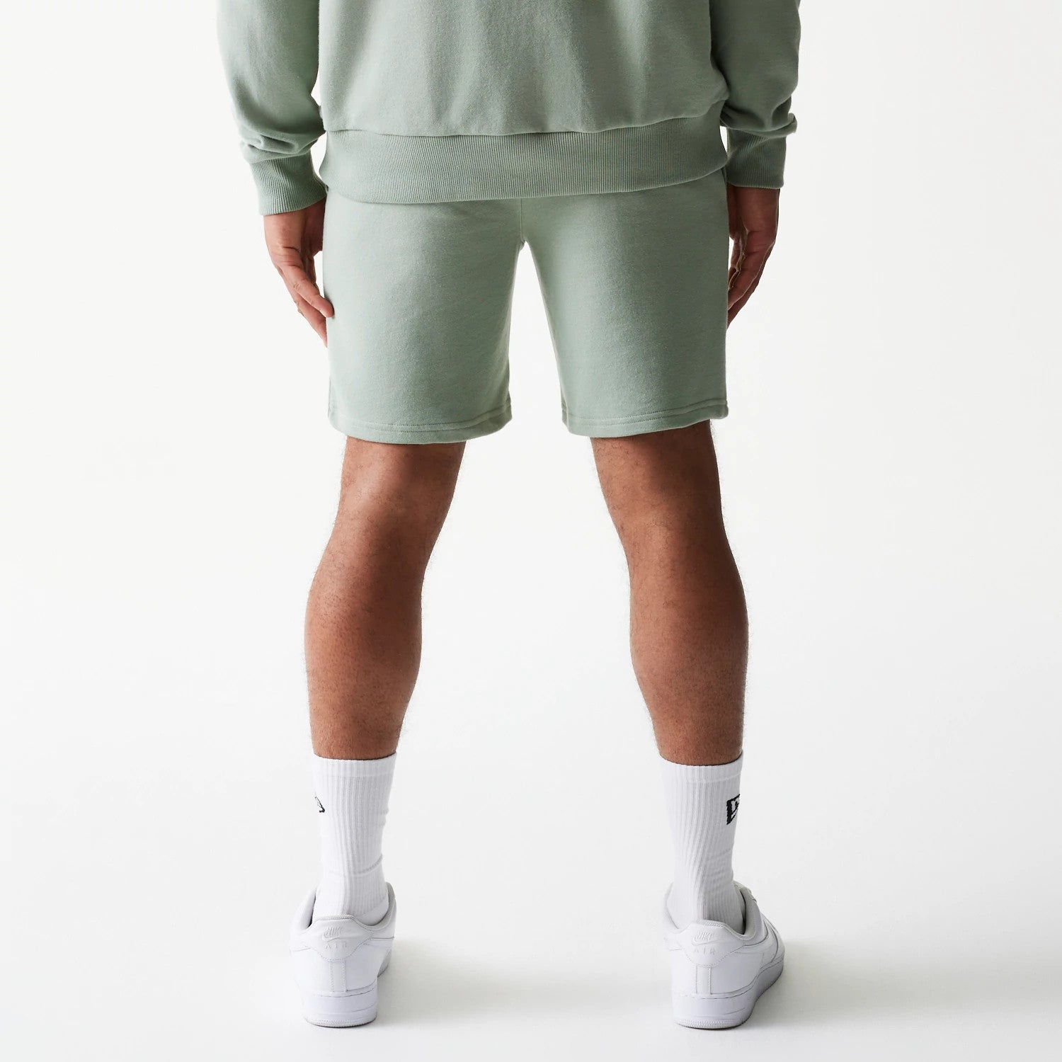 The model is wearing this MLB League Essential Midi LA Dodgers Shorts in green. 2