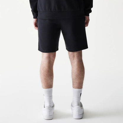 New Era Chicago Bulls NBA Core Black Shorts, back view showing the plain black design with a straight hemline, worn by a model standing, highlighting the simplicity and casual style of the shorts.
