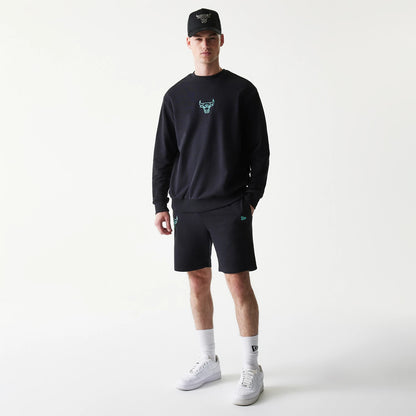 New Era Chicago Bulls NBA Core Black Shorts, front view on-model showing an embroidered teal bulls logo on the left leg, complemented by a matching sweatshirt, New Era logo on the right leg, and a cap styled for a cohesive look.