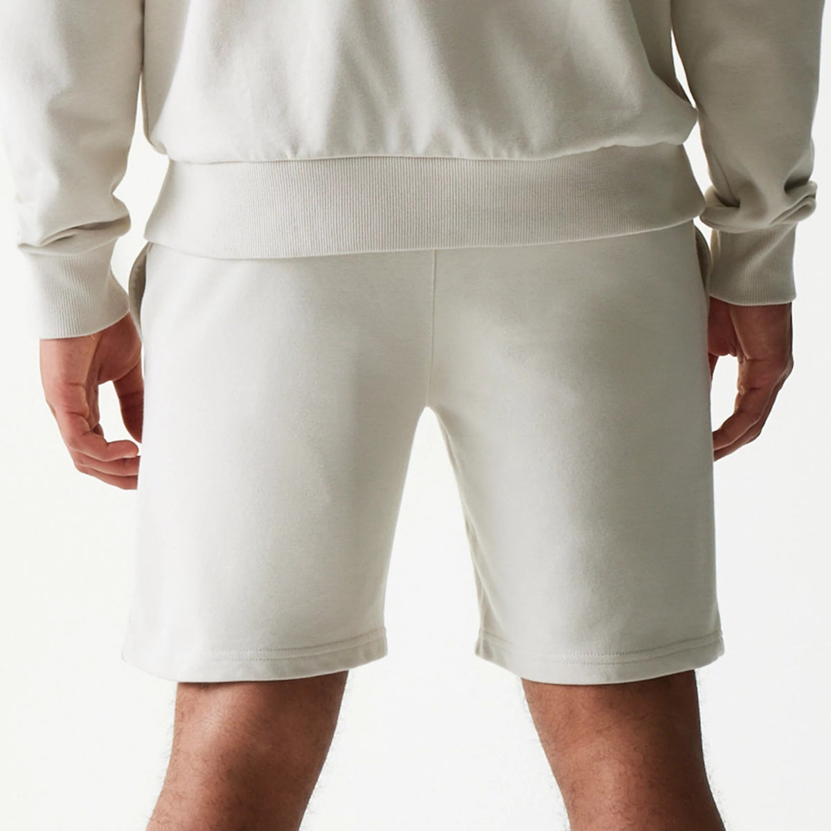 New Era LA Lakers NBA League Essential Light Beige Shorts, back view showing the plain light beige design worn on-model, with a regular fit and a waistband sitting at the natural waistline, paired with a matching top.