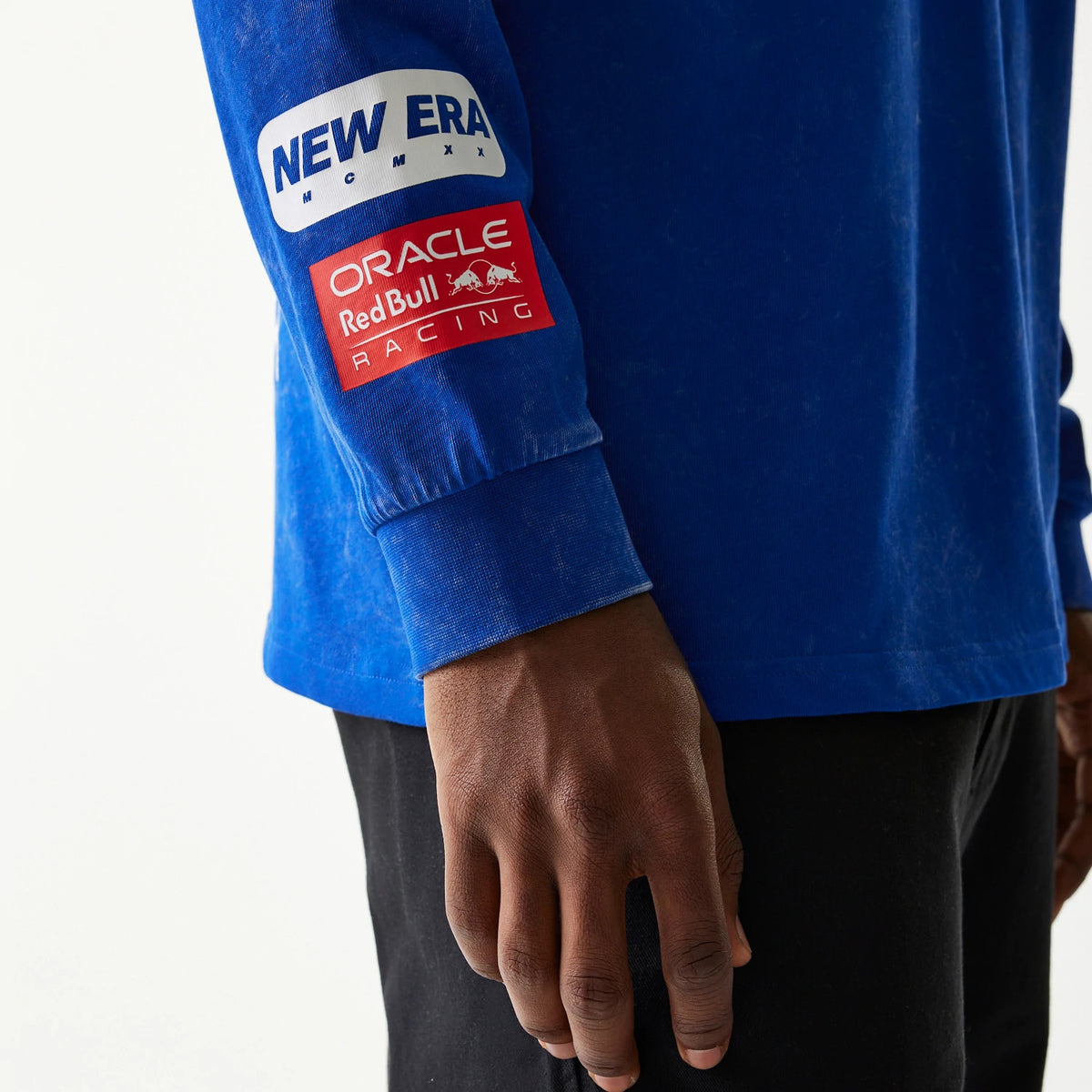 New Era Red Bull Racing Linear Graphic Blue Long Sleeve T-Shirt, three-quarter view showing a partially model wearing the shirt, with New Era and Oracle Red Bull Racing printed logos on the left sleeve.
