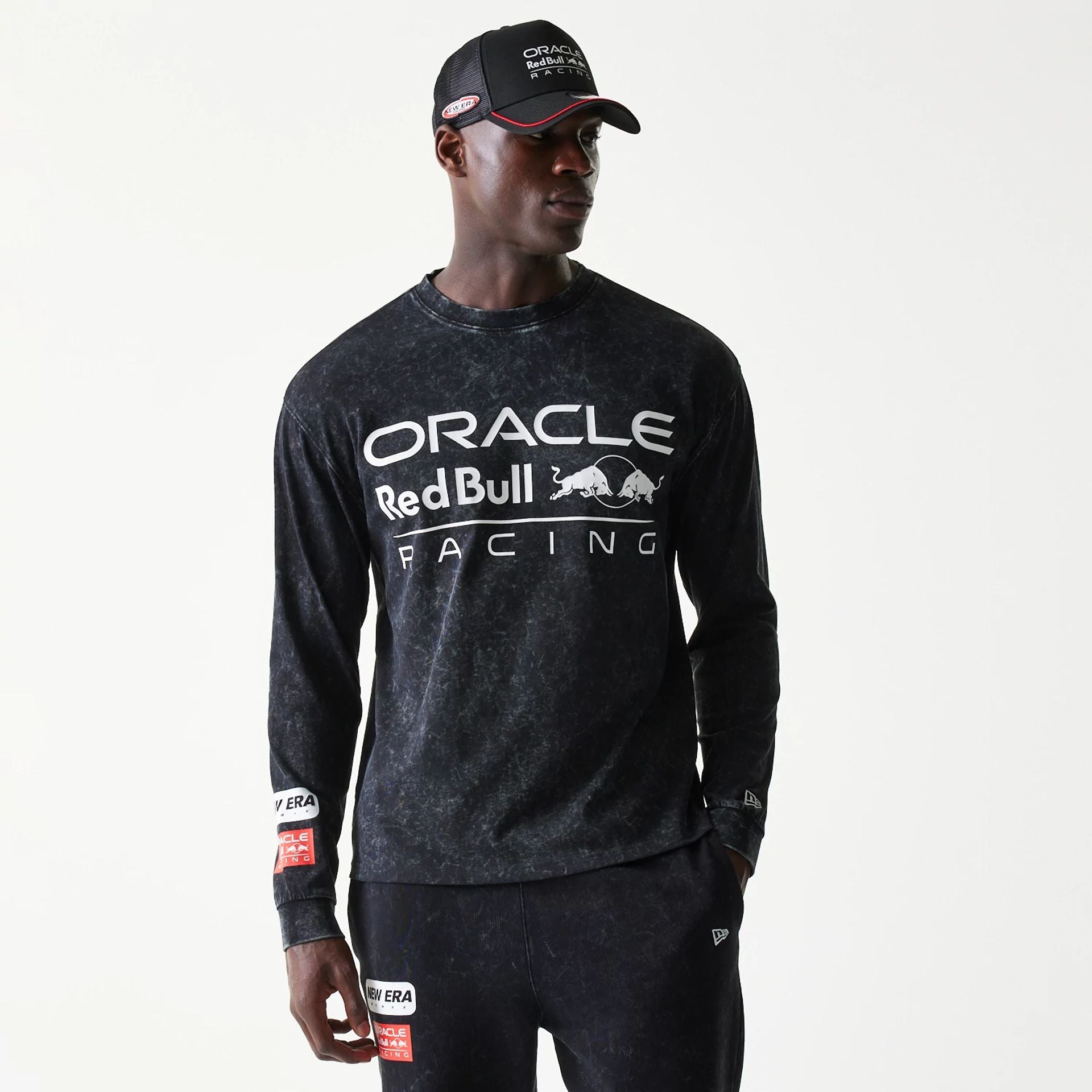 The model is wearing this Red Bull Racing Linear Graphic Long Sleeve T-Shirt in black. 1