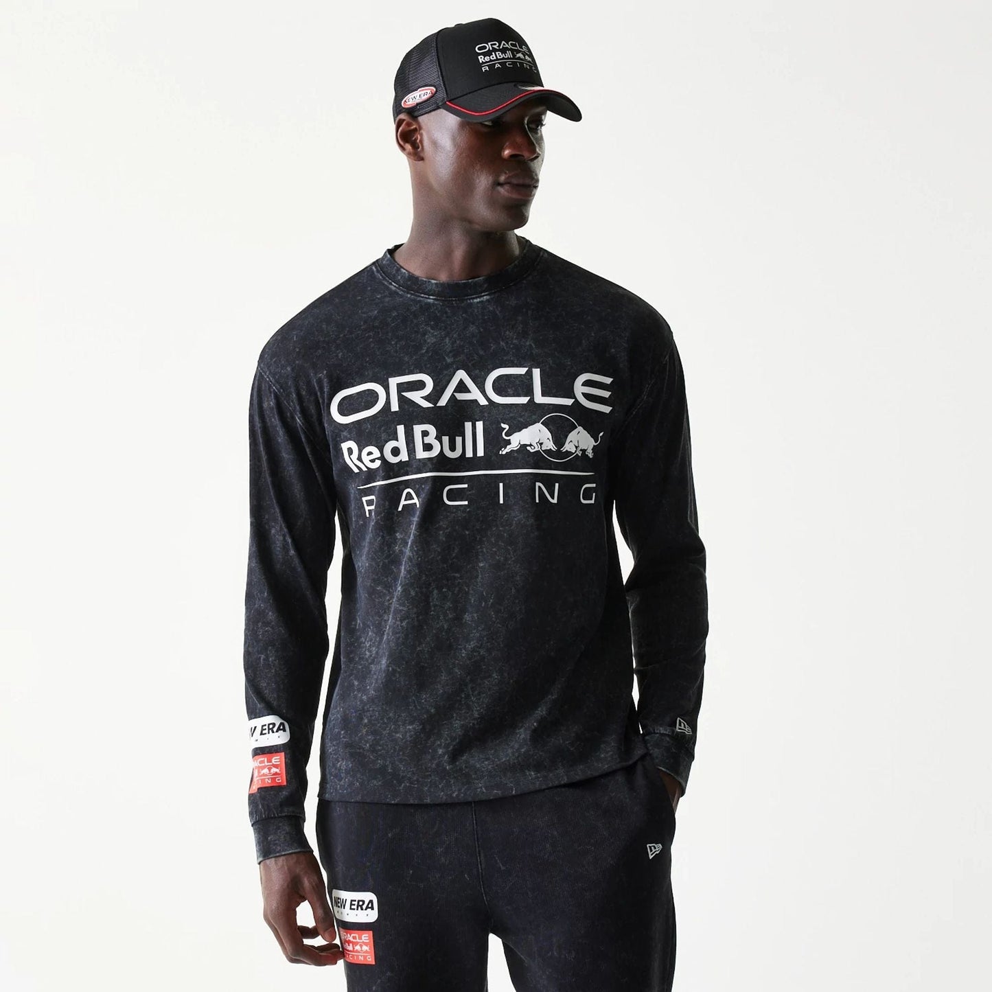 The model is wearing this Red Bull Racing Linear Graphic Long Sleeve T-Shirt in black. 1
