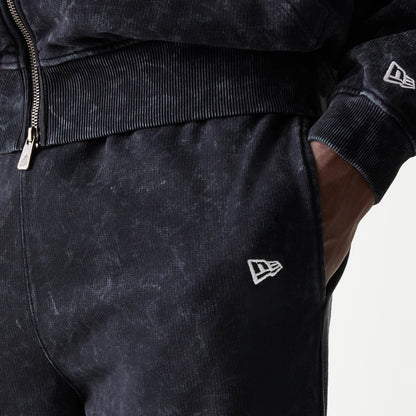New Era Red Bull Racing Straight Leg Black Straight Leg Joggers, close-up view showing white embroidered New Era flag logo on the left hip, with ribbed waistband and the model's hand in the pocket.