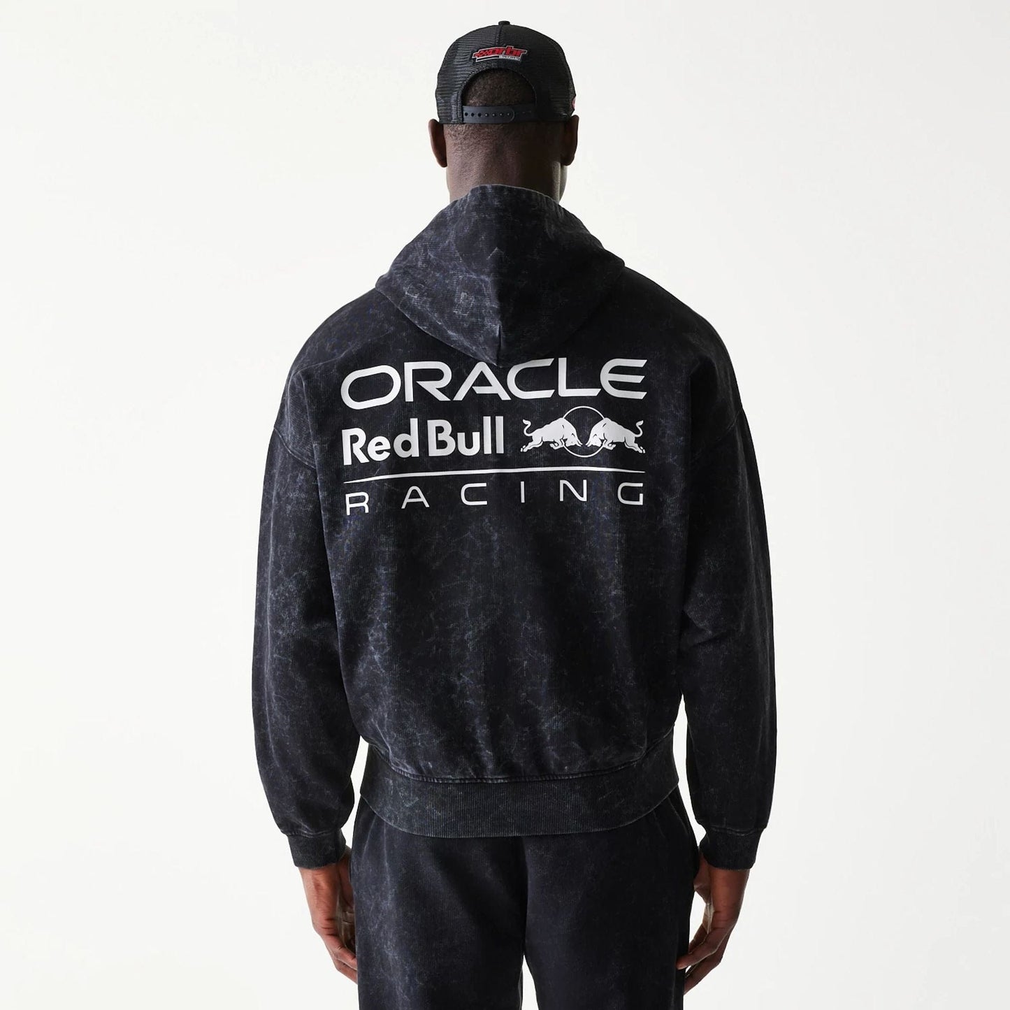 The model is wearing this Red Bull Racing Dropped Shoulder Full Zip Hoodie in black. 2