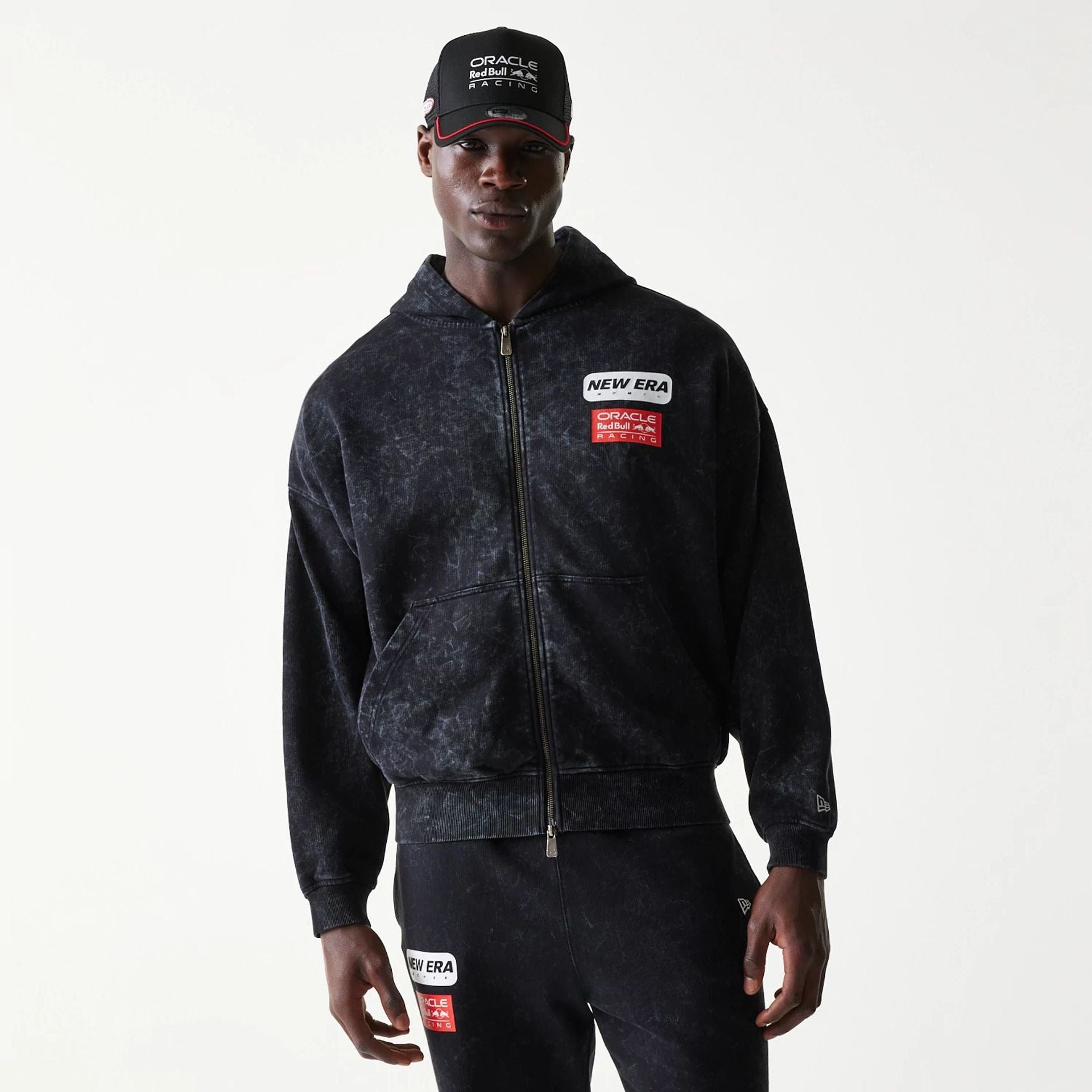 The model is wearing this Red Bull Racing Dropped Shoulder Full Zip Hoodie in black. 1