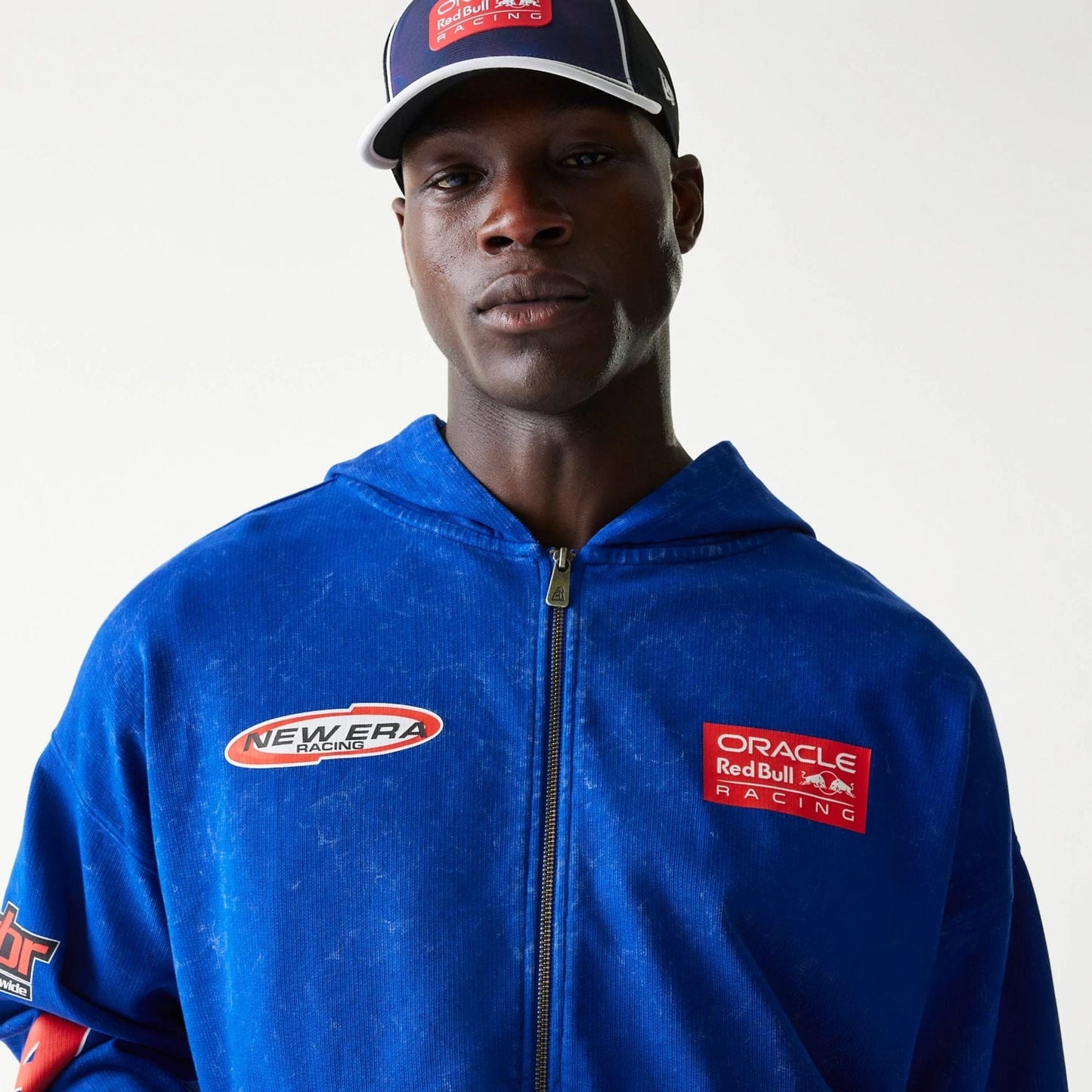 The model is wearing this Red Bull Racing Graphic Dropped Shoulder Full Zip Hoodie in blue. 4