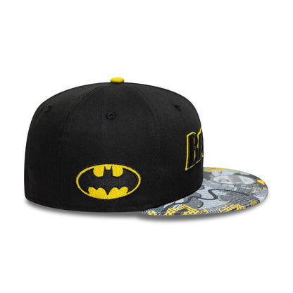 Youth DC Batman Black New Era 9FIFTY Snapback Cap, side view showing the yellow and black embroidered Batman logo on the left side, with a flat multicoloured graphic visor and a yellow top button.