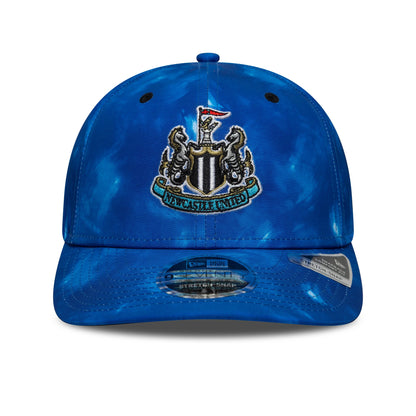 Newcastle United FC 1993 Open Blue New Era 9SEVENTY Stretch Snap Cap, front view showing the raised embroidered club crest in the centre of the blue tie-dye patterned crown, with blue curved visor and 9SEVENTY size sticker.