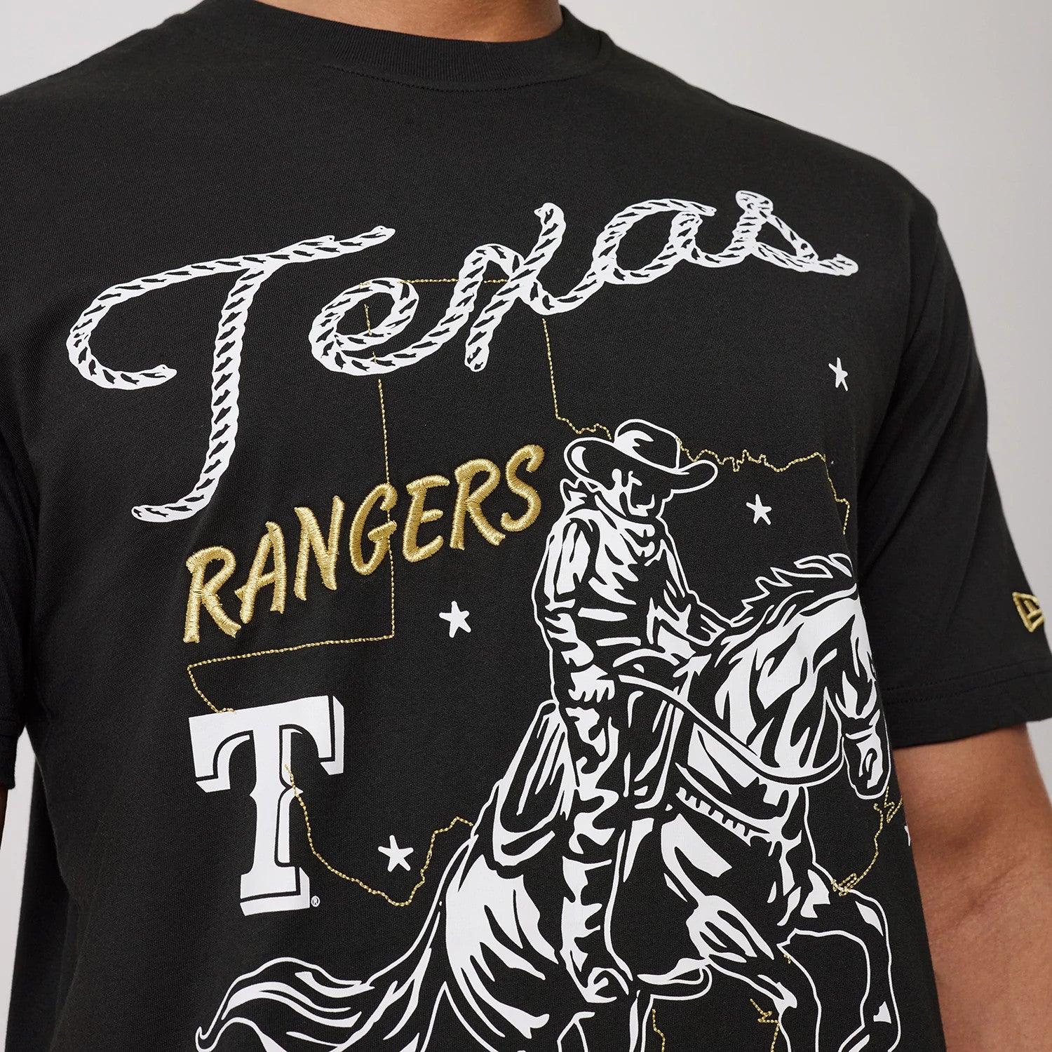 The model is wearing this MLB Cowboy Graphic Texas Rangers T-Shirt in black. 3
