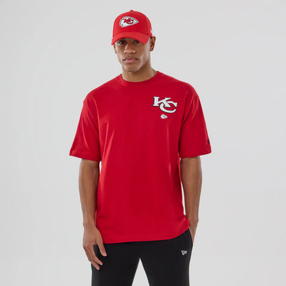 New Era Kansas City Chiefs NFL Graphic Red T-Shirt, front view on-model paired with a matching red cap, featuring an embroidered KC logo on the left chest and a small circular team logo beneath it.