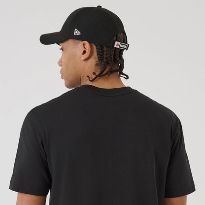 New Era Las Vegas Raiders NFL Sport Classic Black T-Shirt, back view on-model with a matching black cap, displaying the plain black back of the shirt and an embroidered New Era logo on the side of the cap.