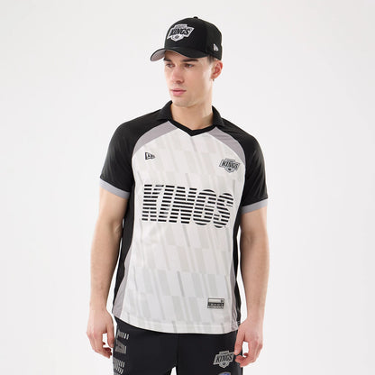 New Era LA Kings NHL Match Black T-Shirt, front view on a model with matching cap, showing the Kings lettering across the chest, a printed Kings logo on the upper right chest and a New Era logo on the left.