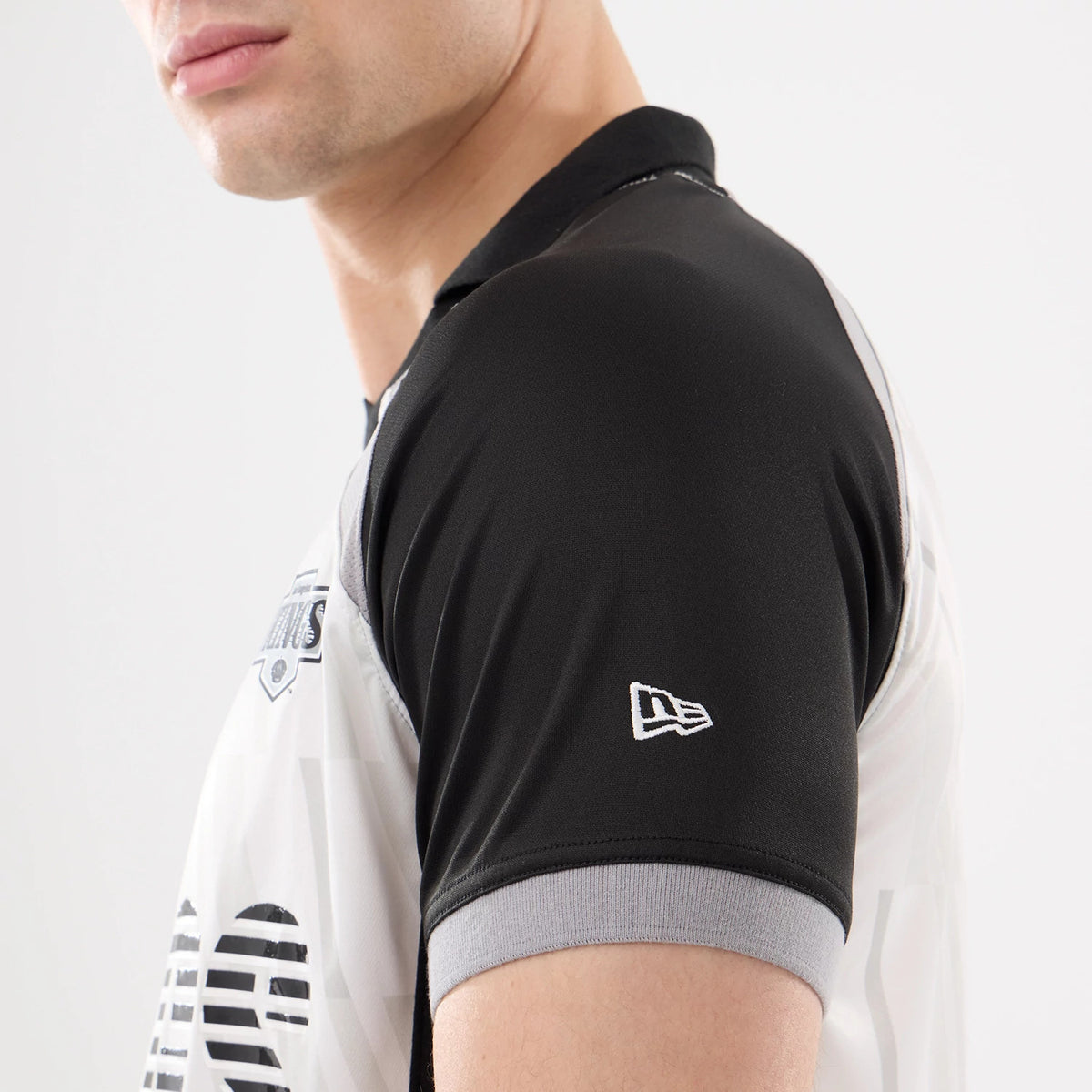 New Era LA Kings NHL Match Black T-Shirt, side view on-model showing the black and grey short sleeves, an embroidered New Era logo on the left sleeve, and part of the team emblem on the chest.