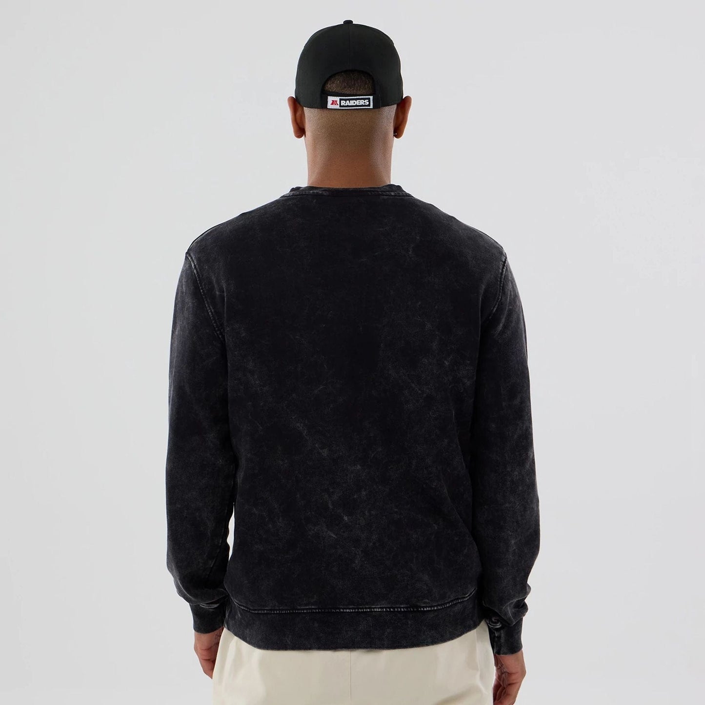 The model is wearing this NFL Las Vegas Raiders Crew Neck Sweater in black. 2