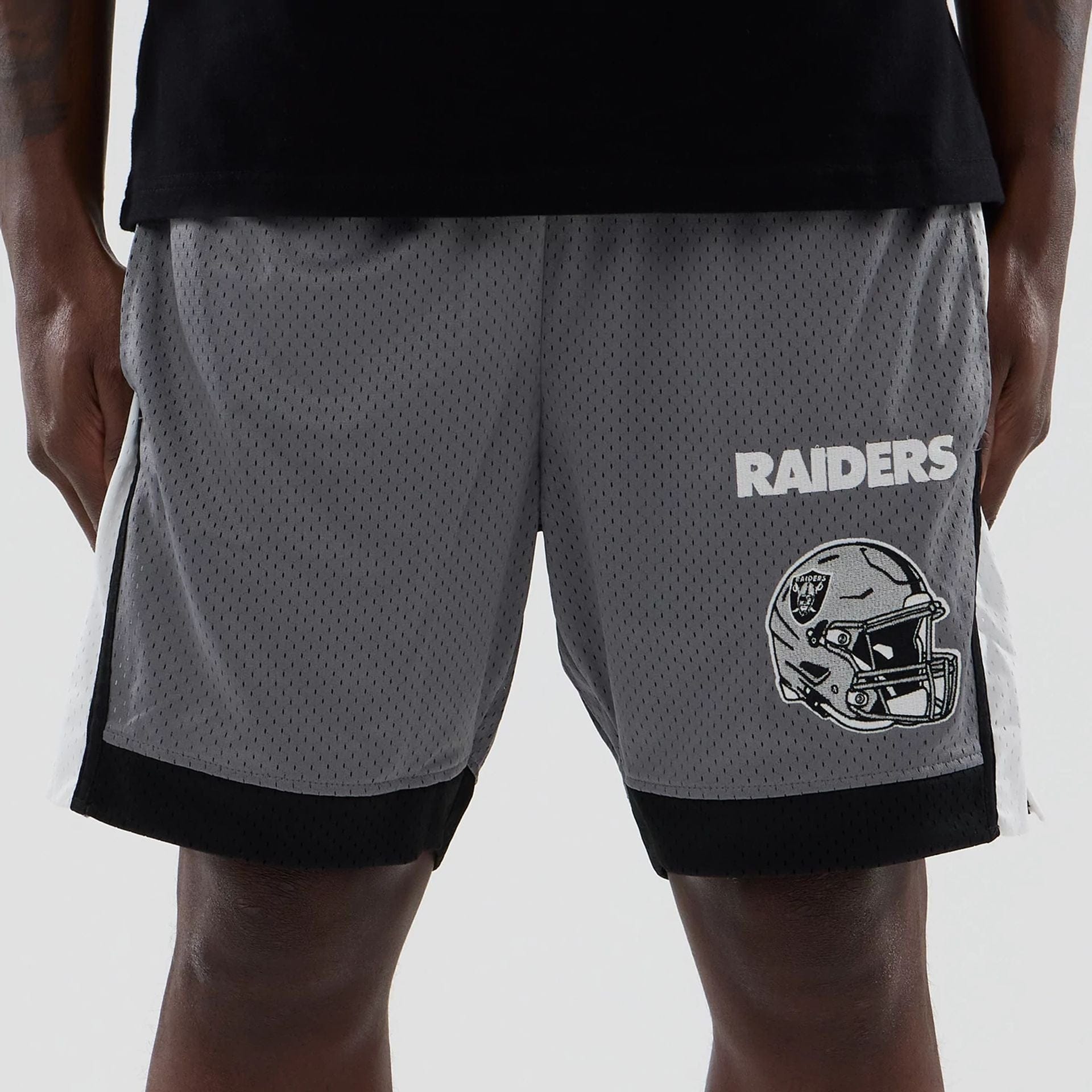 The model is wearing these NFL Las Vegas Raiders Mesh Shorts in grey. 2