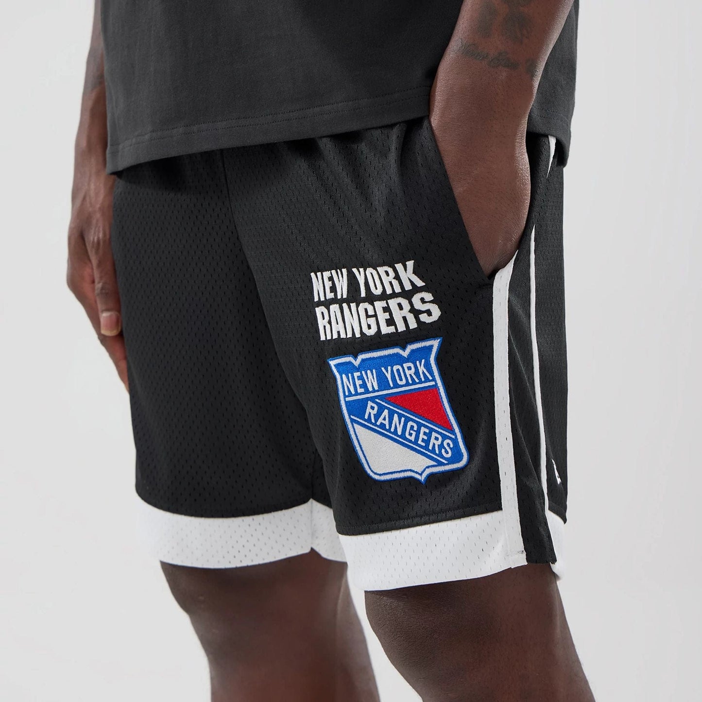 The model is wearing these NHL New York Rangers Mesh Shorts in black. 3