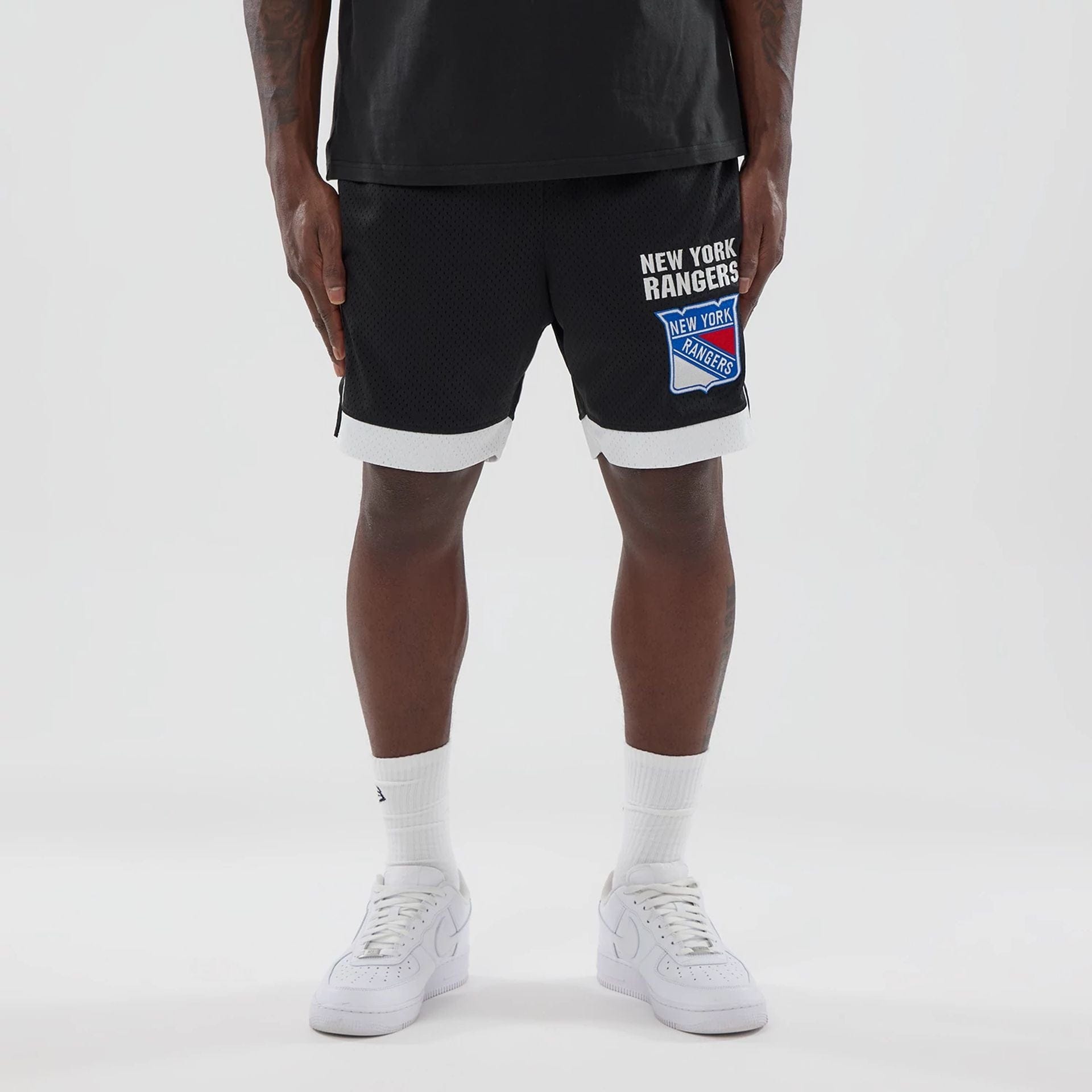 The model is wearing these NHL New York Rangers Mesh Shorts in black. 1