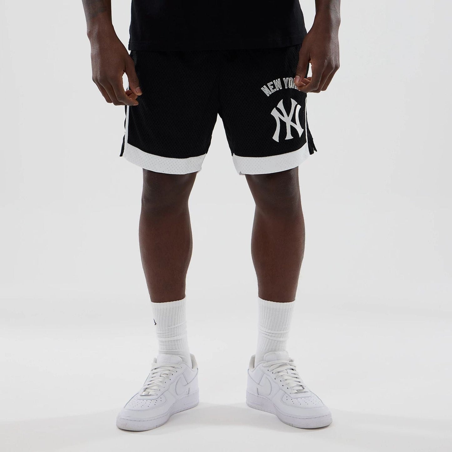 The model is wearing these MLB New York Yankees Mesh Shorts in black. 1