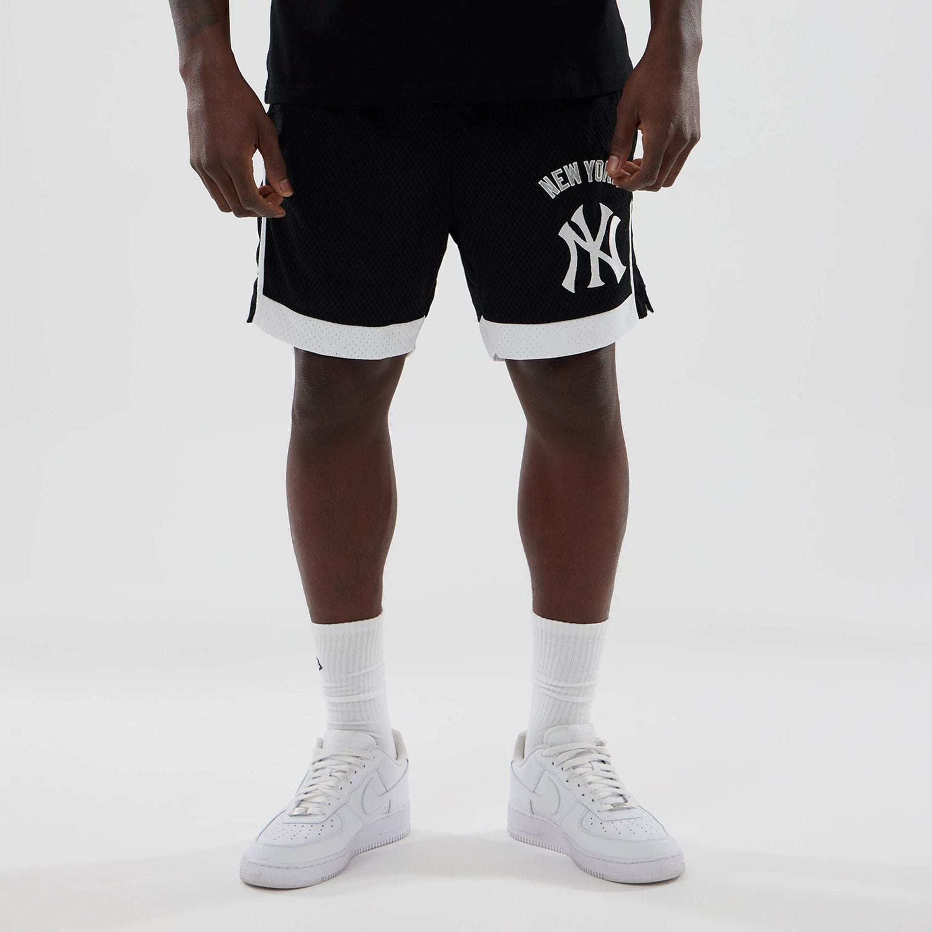 The model is wearing these MLB New York Yankees Mesh Shorts in black. 1