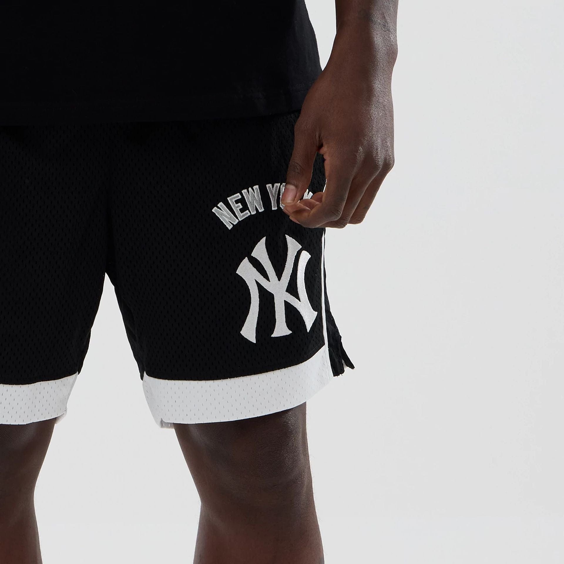 The model is wearing these MLB New York Yankees Mesh Shorts in black. 5