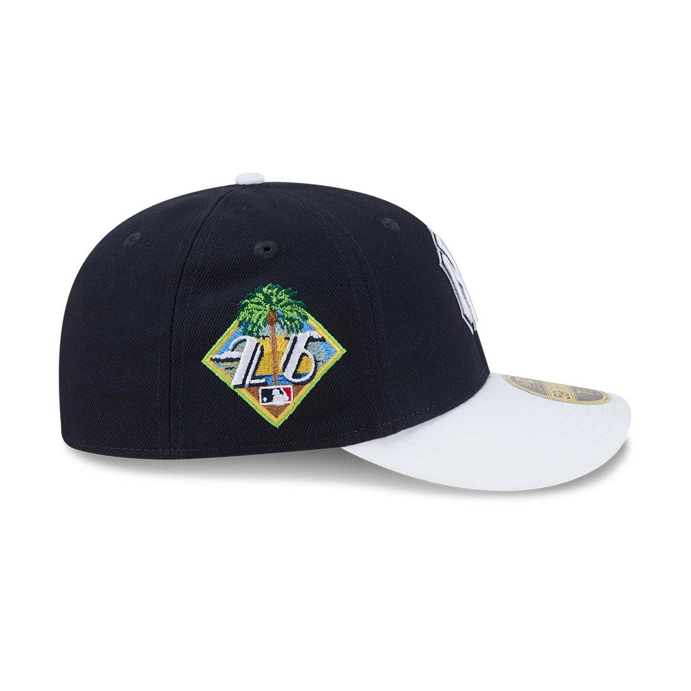 Yankees MLB Spring Training 2026 Navy Low Profile New Era 59FIFTY Fitted Cap, side view showing a colourful Spring Training patch embroidered on the right panel of the navy crown, with a contrasting white visor featuring a gold 59FIFTY size sticker.