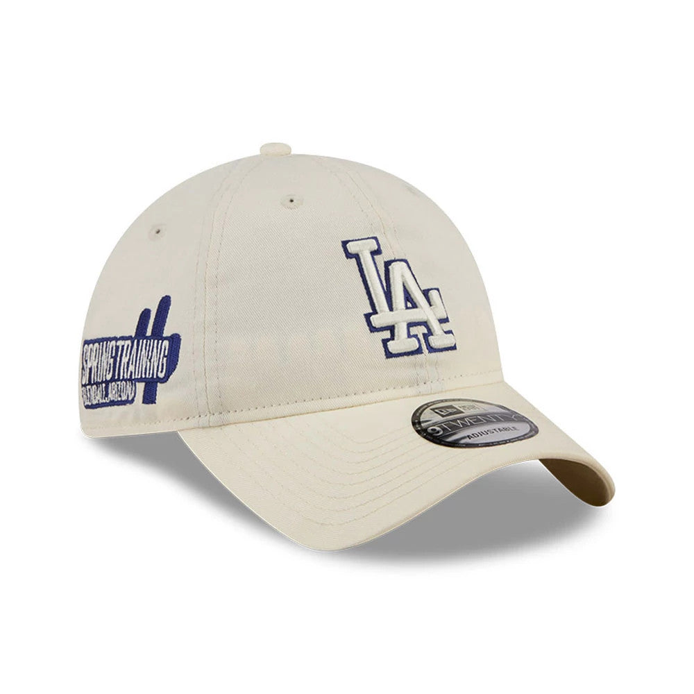 LA Dodgers MLB Colours White New Era 9TWENTY Adjustable Cap, three-quarter view showing the blue embroidered LA logo on the front panel, curved white visor with a 9TWENTY size sticker, and a graphic patch on the left side.