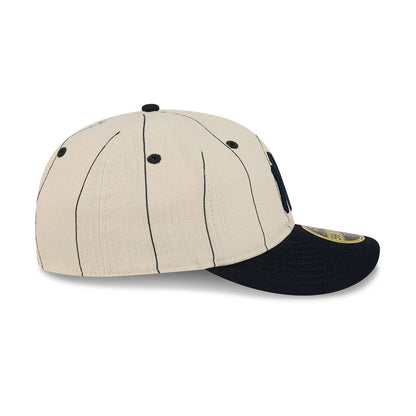 New York Yankees MLB Linen Cream Retro Crown New Era 59FIFTY Fitted Cap, side view showing the black New Era flag logo on the left, with black pinstripes on the cream panels and a contrasting black visor featuring a gold 59FIFTY size sticker.