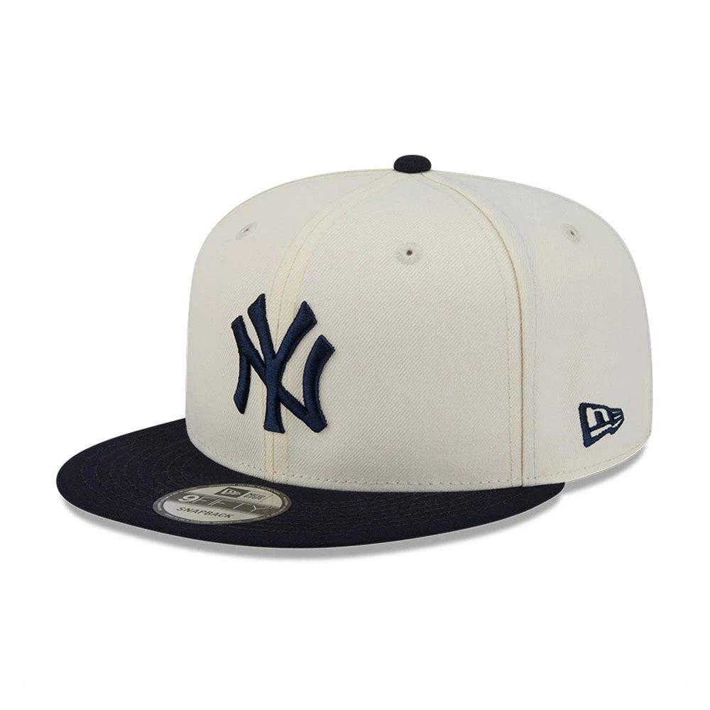 New York Yankees MLB Localized White New Era 9FIFTY Snapback Adjustable Cap, three-quarter view showing the navy raised embroidered NY logo on the front panel, matching navy visor, and New Era flag logo on the left side.