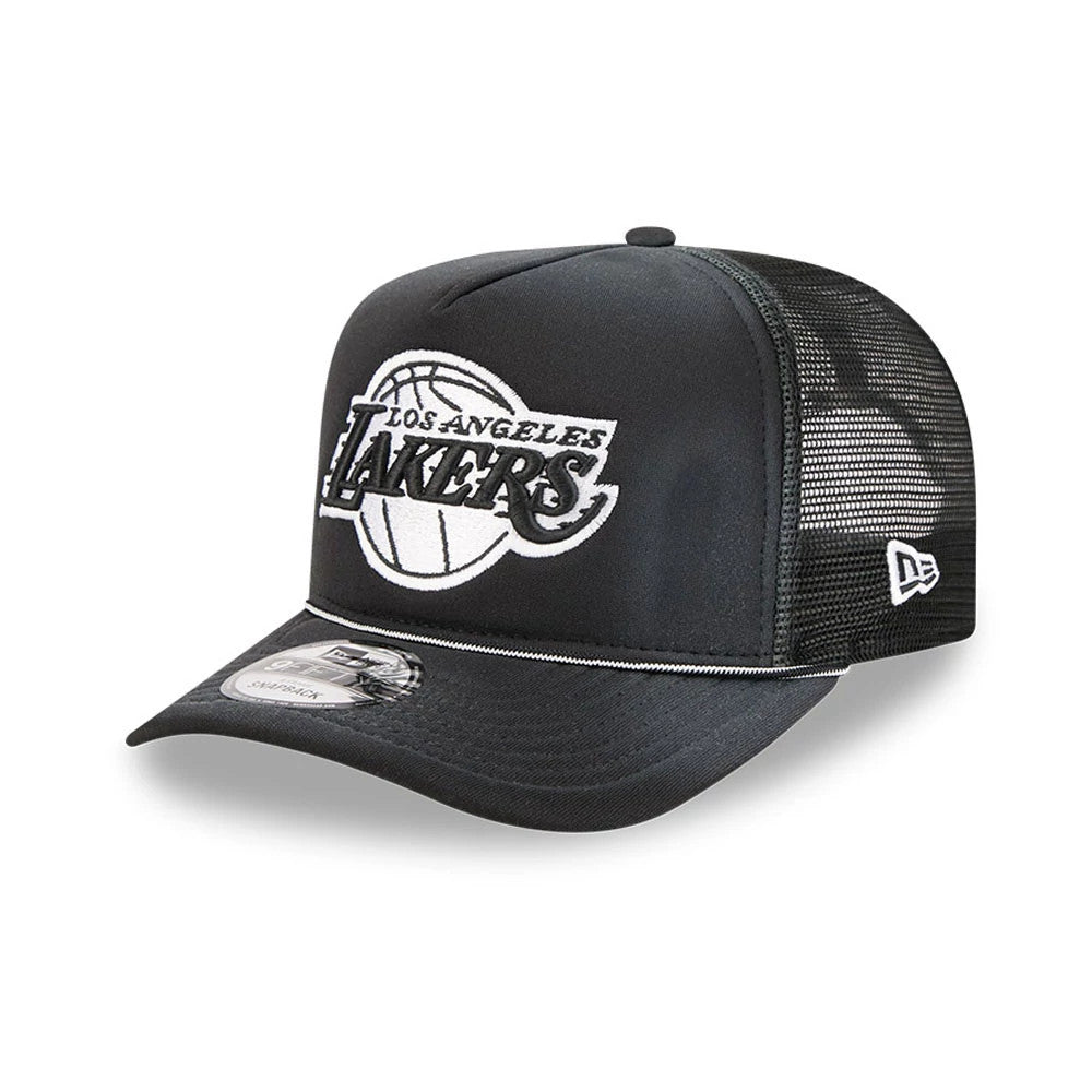 LA Lakers NBA Washed Black New Era 9FIFTY A-Frame Trucker Adjustable Cap, three-quarter view with a raised white Lakers logo on the front panel, black curved visor with a 9FIFTY size sticker, and mesh back panels featuring the New Era flag logo.