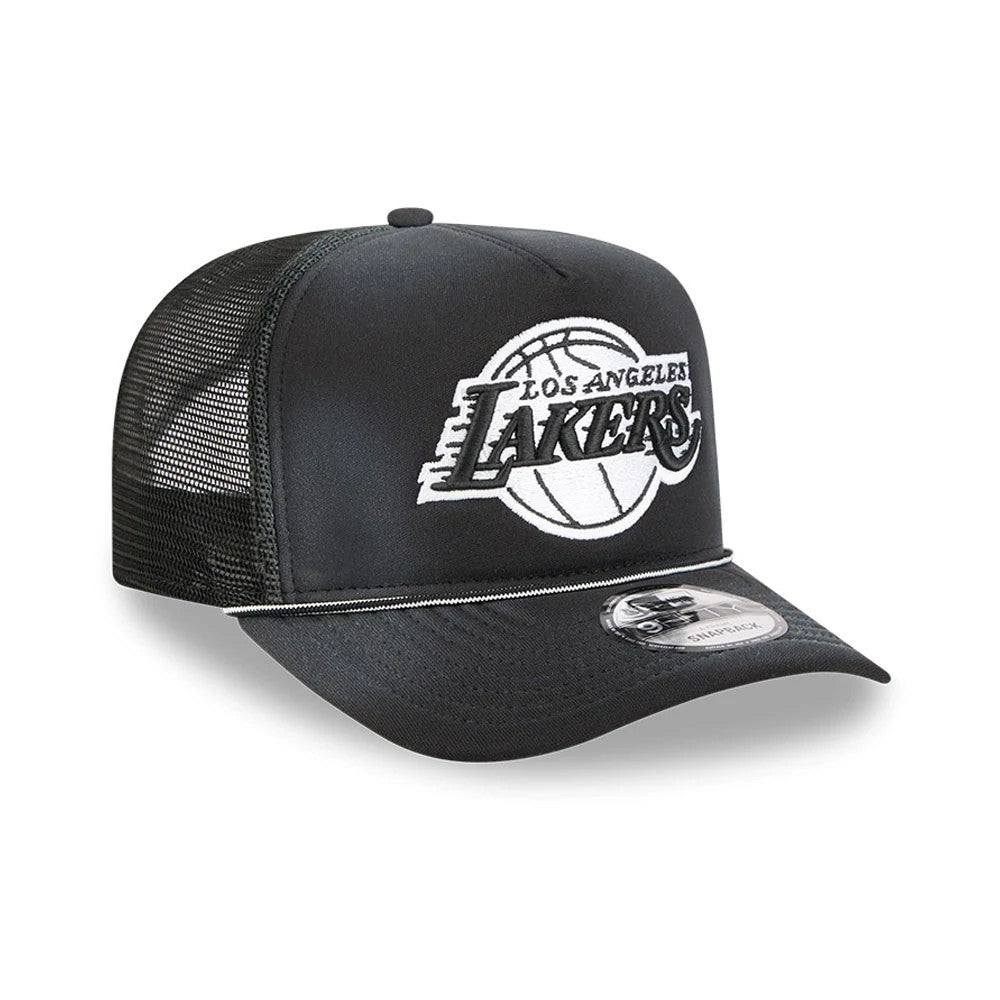 LA Lakers NBA Washed Black New Era 9FIFTY A-Frame Trucker Adjustable Cap, three-quarter view showing the raised white and black embroidered Lakers graphic on the front panel, black mesh sides, and a 9FIFTY size sticker on the black flat visor.
