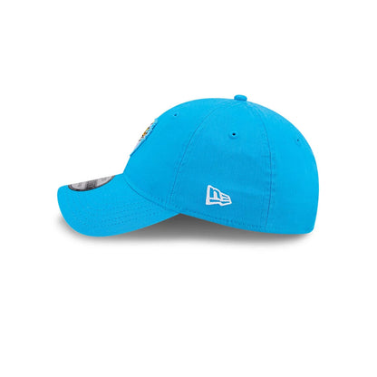 Hey Arnold Heart Blue New Era 9TWENTY Adjustable Cap, side view showing the white New Era flag logo embroidered on the left side of the blue unstructured crown and the slightly curved visor with a 9TWENTY size sticker on top.