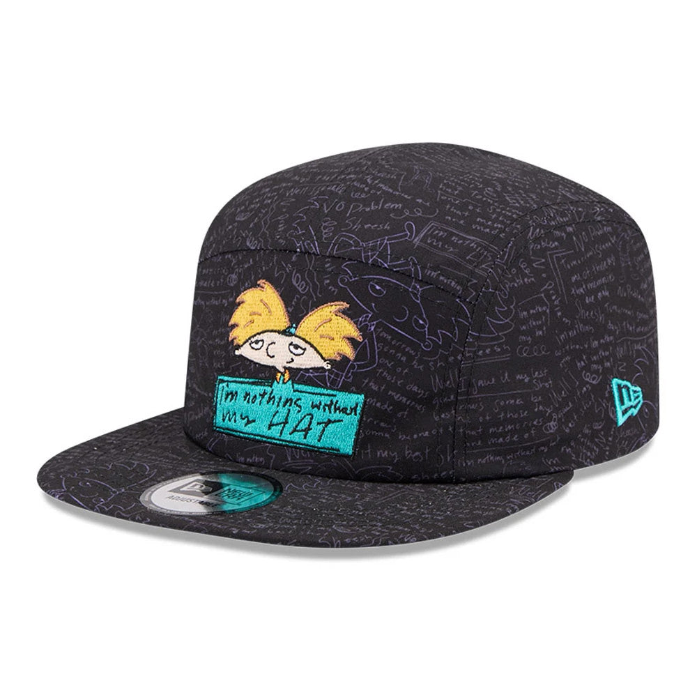 New Era Hey Arnold All Over Print Black Camper Cap, three-quarter view with a colourful embroidered Hey Arnold graphic on the front panel, turquoise text box reading I'm nothing without my hat and New Era flag logo on the left side.