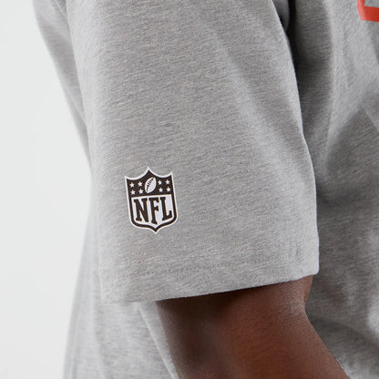 New Era Cleveland Browns NFL International Series Games Grey Oversized T-Shirt, three-quarter view showing a white printed NFL shield logo on the left sleeve, highlighting the shirt's relaxed fit and design detail.
