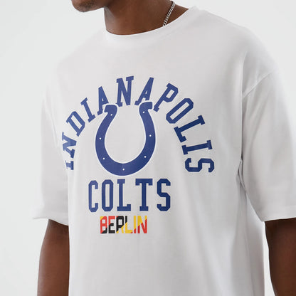 New Era Indianapolis Colts NFL International Series Games White Oversized T-Shirt, front view showing blue printed Indianapolis Colts lettering and horseshoe design, with Berlin lettering in red and yellow beneath