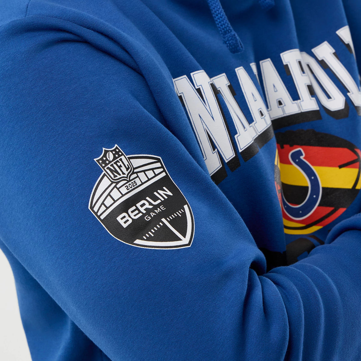 New Era Indianapolis Colts NFL International Series Games Blue Pullover Hoodie, three-quarter view showing a printed NFL Berlin Game shield logo on the left sleeve and Indianapolis lettering across the chest with the Colts logo.