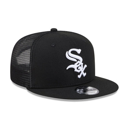 Chicago White Sox MLB Evergreen Black New Era 9FIFTY Trucker Adjustable Cap, three-quarter view showing the black visor with a 9FIFTY size sticker, and a raised white embroidered team logo on the front panel with mesh back panels.