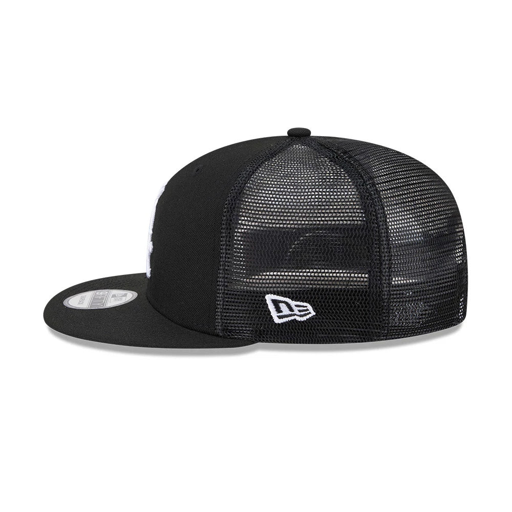 Chicago White Sox MLB Evergreen Black New Era 9FIFTY Trucker Adjustable Cap, side view showing the white embroidered New Era flag logo on the black mesh panels and a grey 9FIFTY size sticker on the flat black visor.