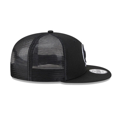 New York Yankees MLB Evergreen Black New Era 9FIFTY Trucker Adjustable Cap, side view showing the white embroidered Yankees logo on the front panel, black mesh back panels, and a black flat visor with a 9FIFTY size sticker.