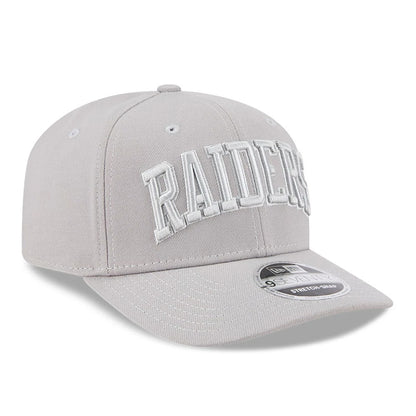 Las Vegas Raiders NFL Script Grey New Era 9SEVENTY Stretch Snap Adjustable Cap, three-quarter view showing the raised white Raiders script lettering on the front panel, grey curved visor and 9SEVENTY size sticker on top.