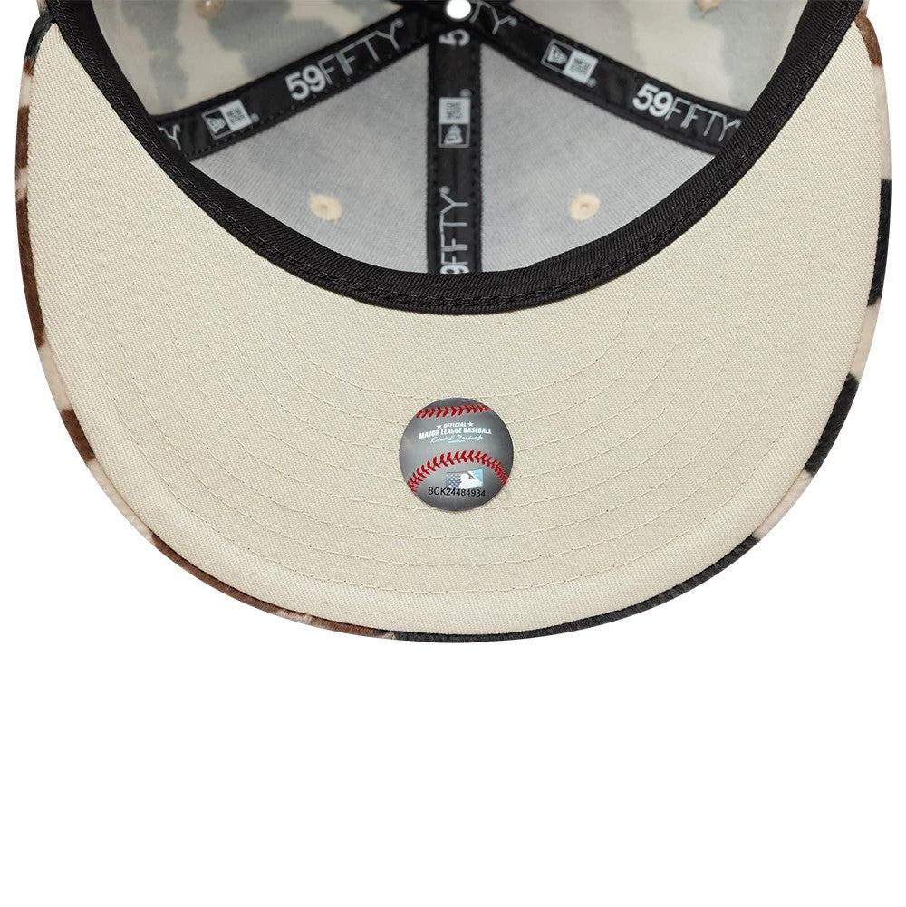 New York Yankees Animal Print Cow Beige New Era 59FIFTY Fitted Cap, inside view showing the beige undervisor with a baseball sticker, black branded taping, and cow print pattern on the inner edge of the visor.