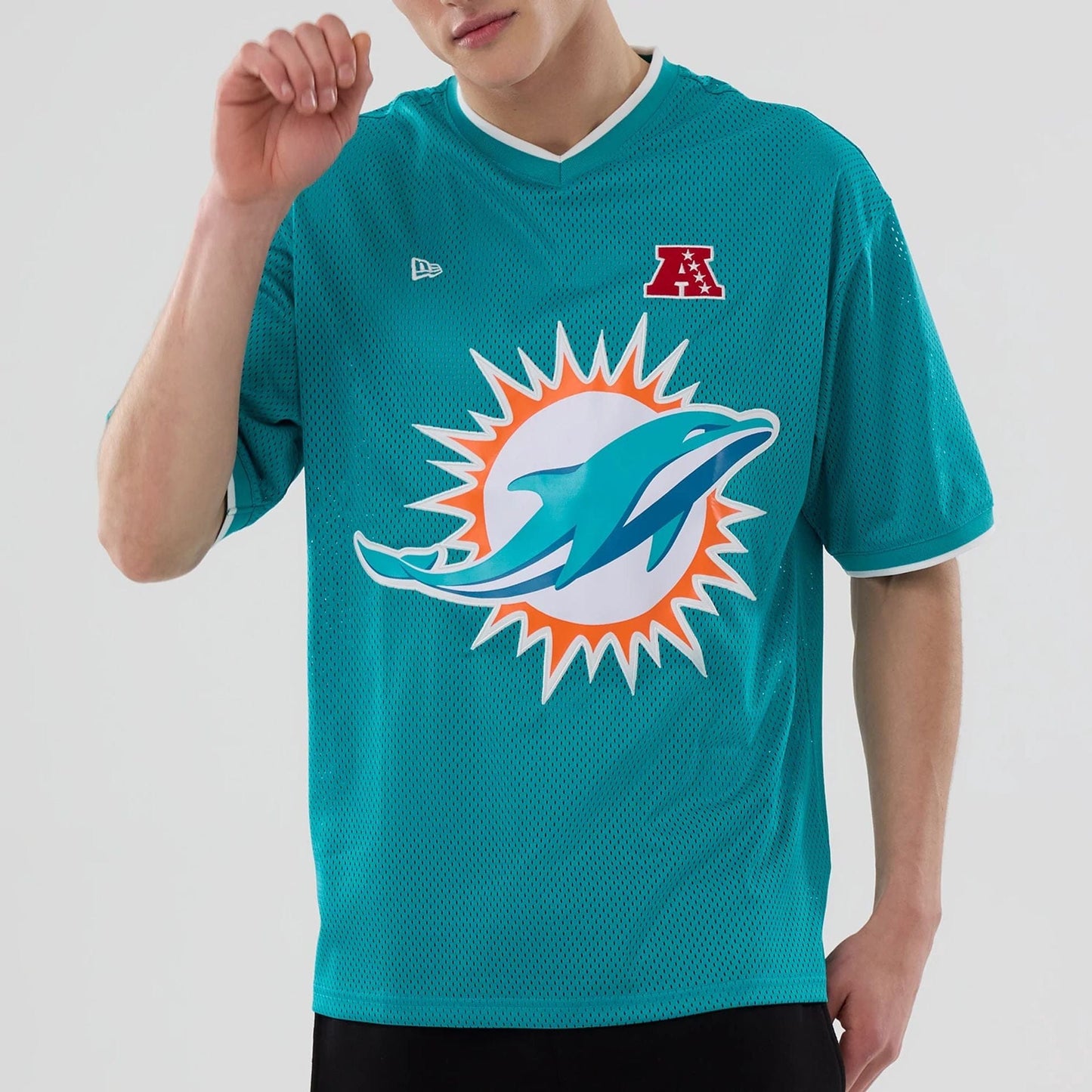 The model is wearing this NFL Mesh Miami Dolphins Oversized T-Shirt in turquoise. 5