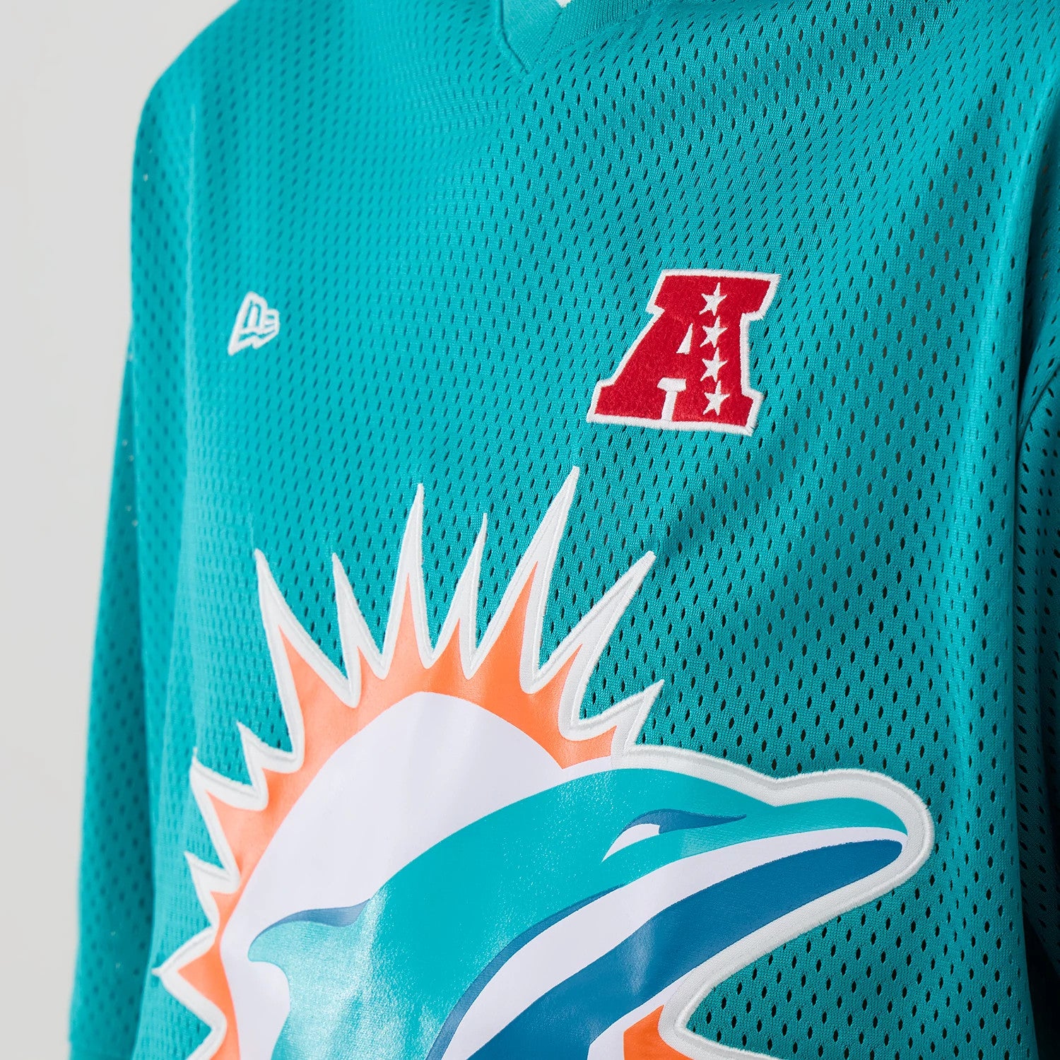 The model is wearing this NFL Mesh Miami Dolphins Oversized T-Shirt in turquoise. 4