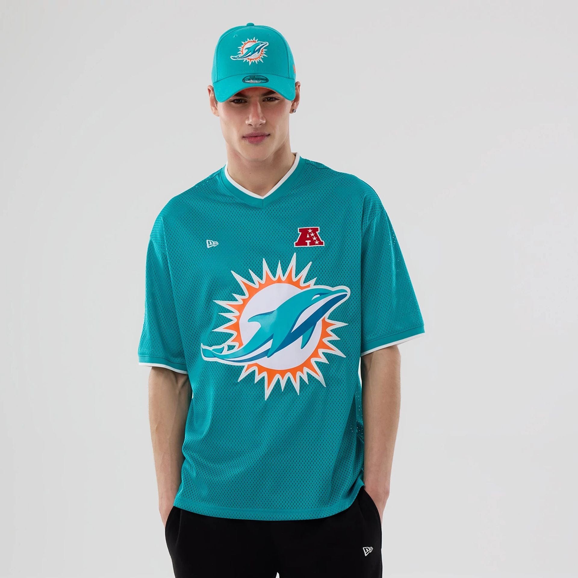 The model is wearing this NFL Mesh Miami Dolphins Oversized T-Shirt in turquoise. 1
