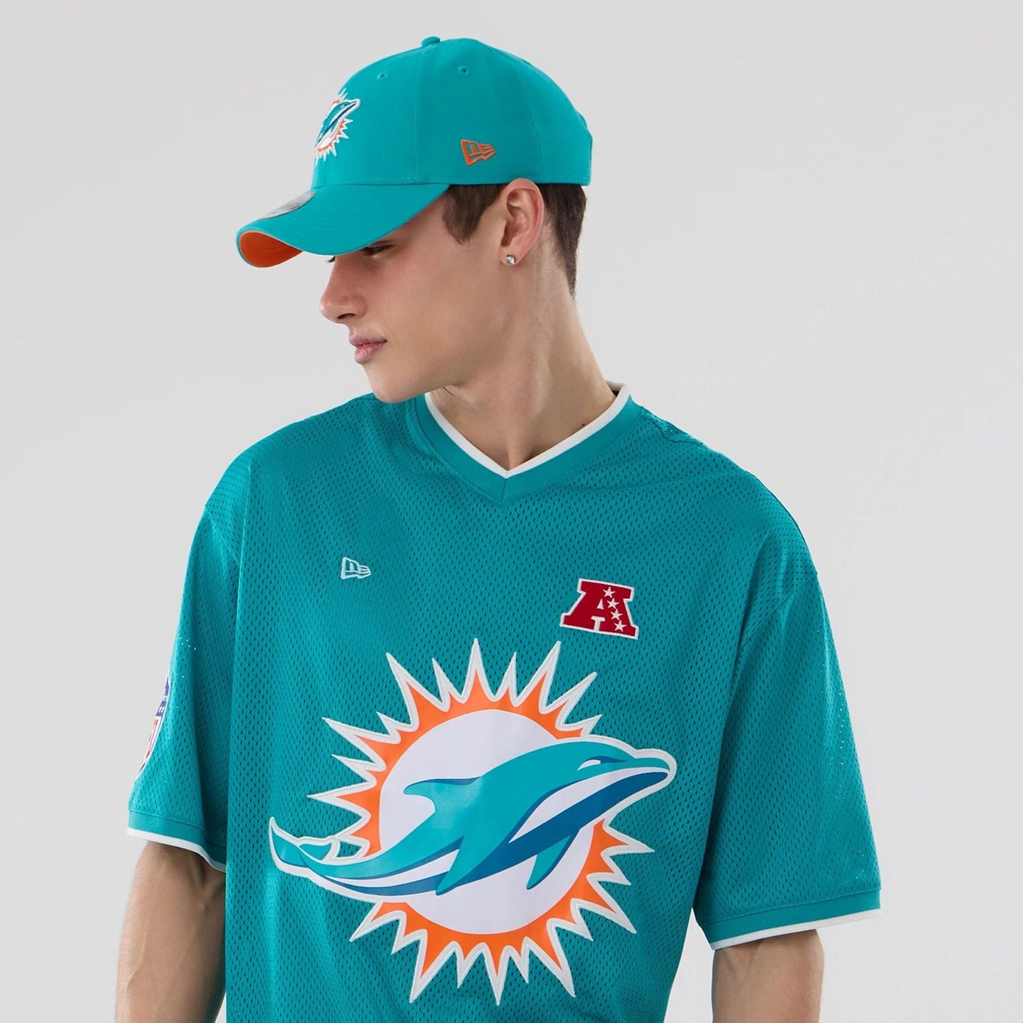 The model is wearing this NFL Mesh Miami Dolphins Oversized T-Shirt in turquoise. 6